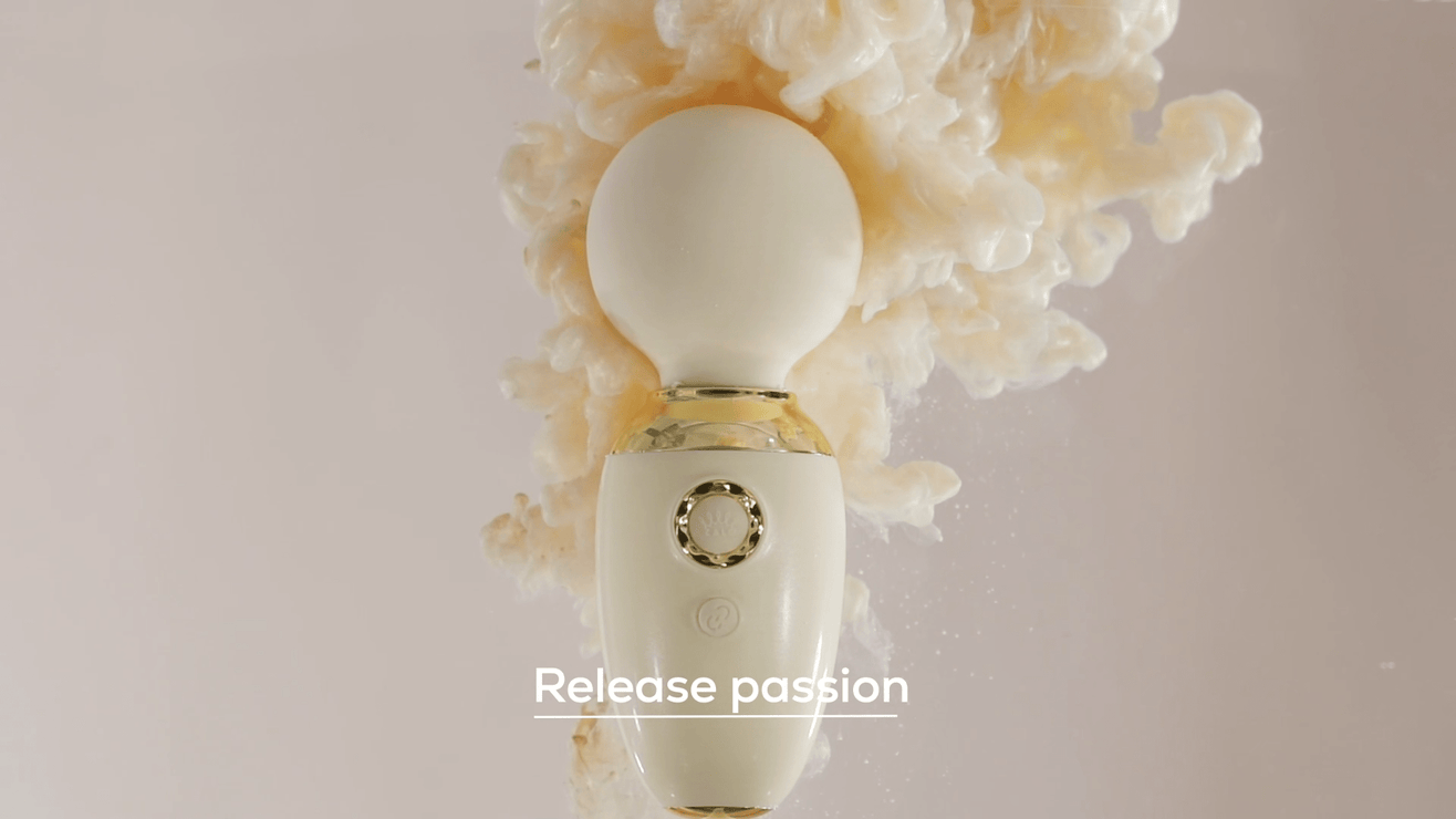 Premium wand vibrator in ivoor met gouden accenten tegen een dromerige beige achtergrond, tagline ‘Release passion