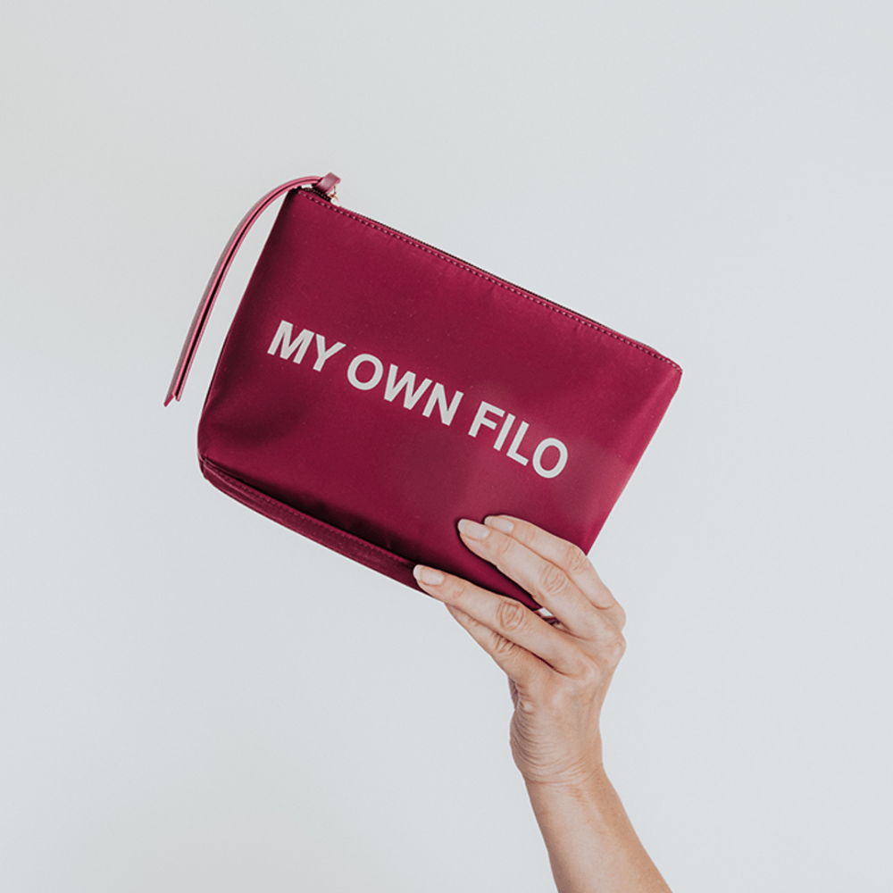 Paarse My Own Filo toilettas in hand close-up rits en formaat luxe opbergtasje