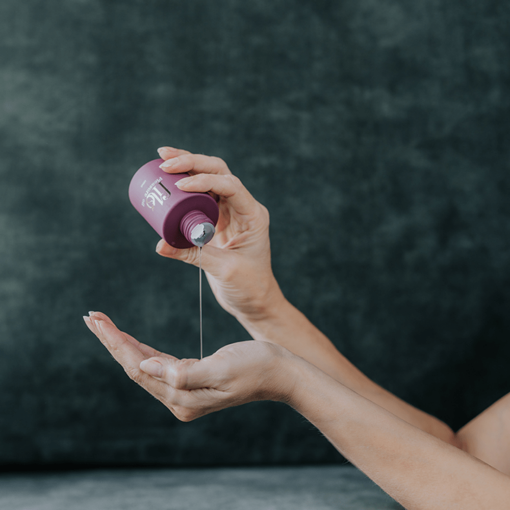 My Own Filo Plezieuroli sensuele massageolie voor lichaam en haar, paars flesje in hand tijdens gebruik