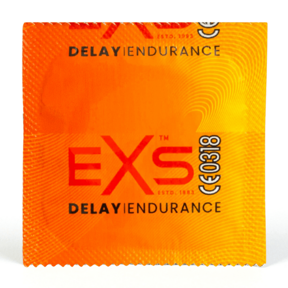 Gele EXS Delay condoomverpakking met rood logo, plat gefotografeerd als losse foil op witte achtergrond
