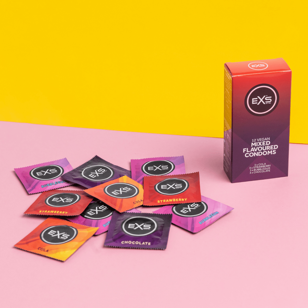 EXS Mixed Flavoured condooms met doosje en losse verpakkingen op roze en gele studiovlakken
