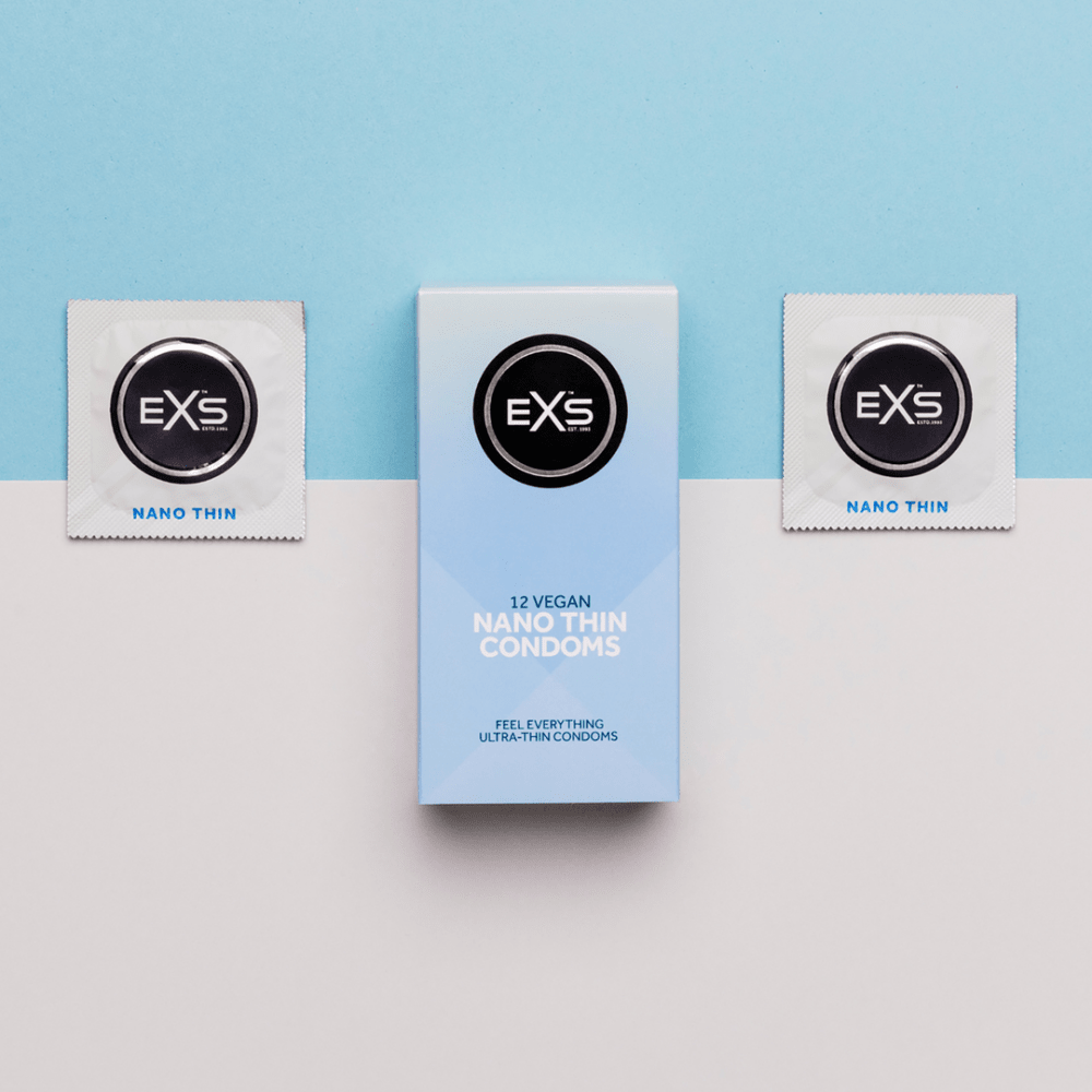 EXS Nano Thin doos met losse condoomfolies op lichte ondergrond, stijlvol gefotografeerd als productset.