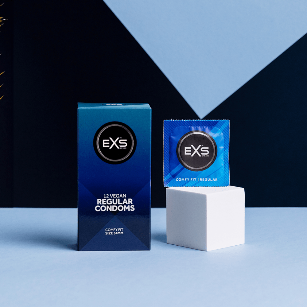 EXS Regular condooms met doosje en los zakje op witte blokken, sfeervol belicht met blauwe achtergrond