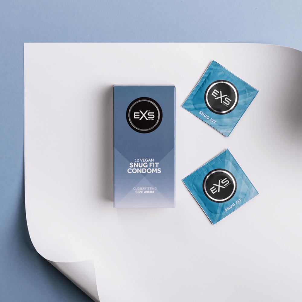 EXS Snug Fit condooms in bovenaanzicht met doosje en twee blauwe wrappers op een lichte ondergrond