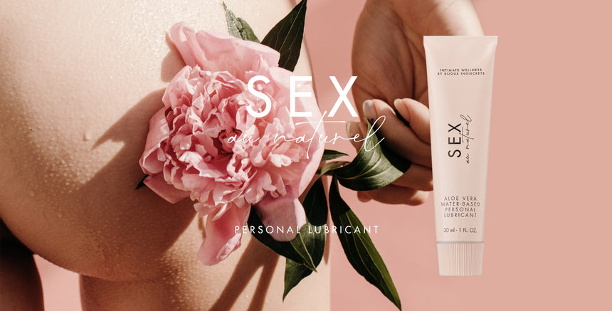 Luxe sensual wellness foto met roze pioenroos en SEX au naturel glijmiddel tube op zachte nude achtergrond