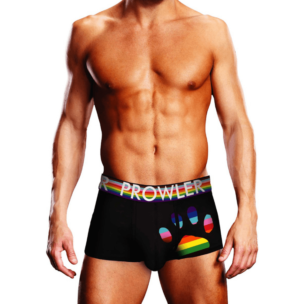 Man draagt Prowler Oversized Paw Trunk zwart maat XS, vooraanzicht met regenboogkleurige PROWLER-tailleband en grote regenboogkleurige pootafdruk op de heup