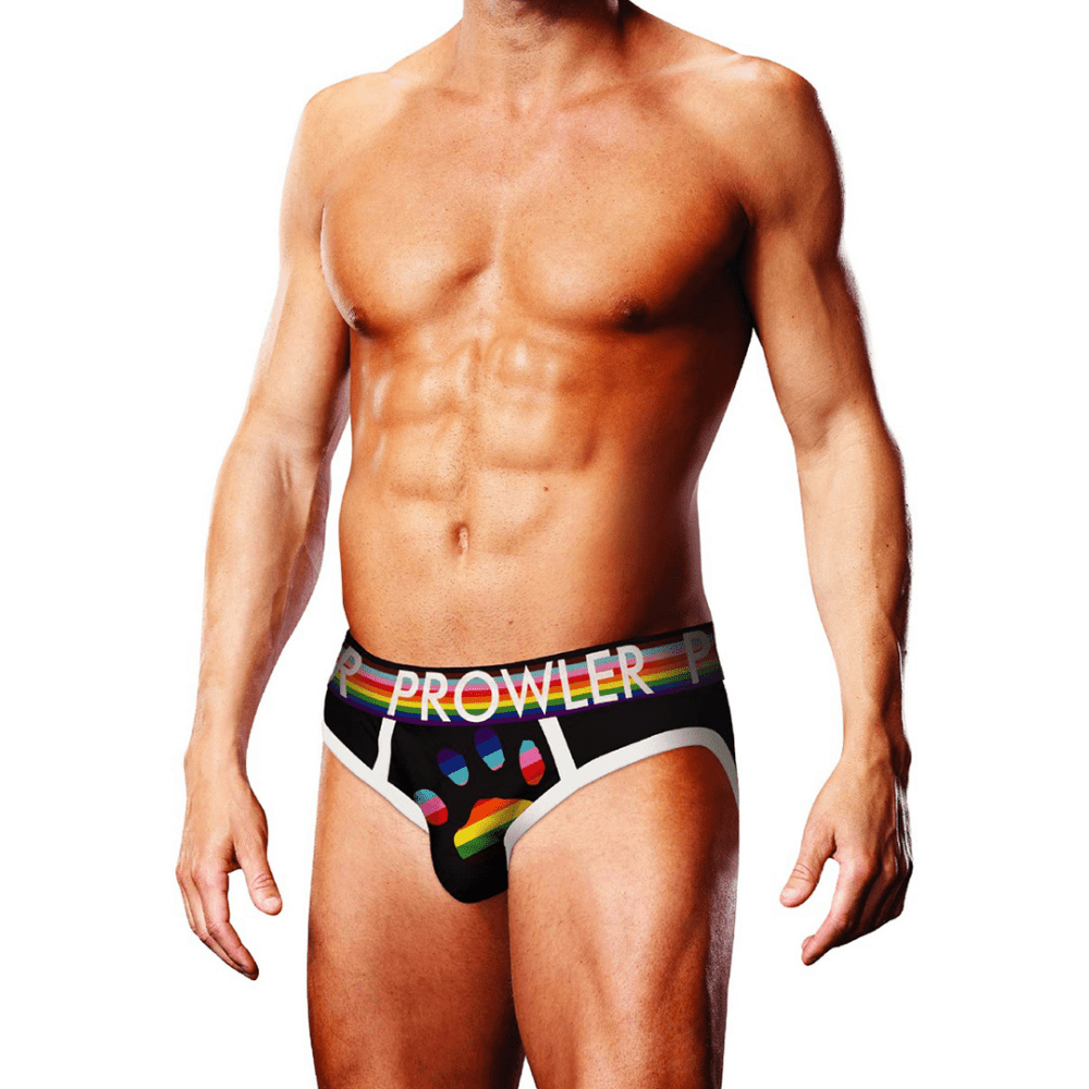 Man draagt Prowler Oversized Paw Brief zwart maat S, vooraanzicht met regenboogkleurige PROWLER-tailleband en grote regenboogkleurige pootafdruk op de pouch