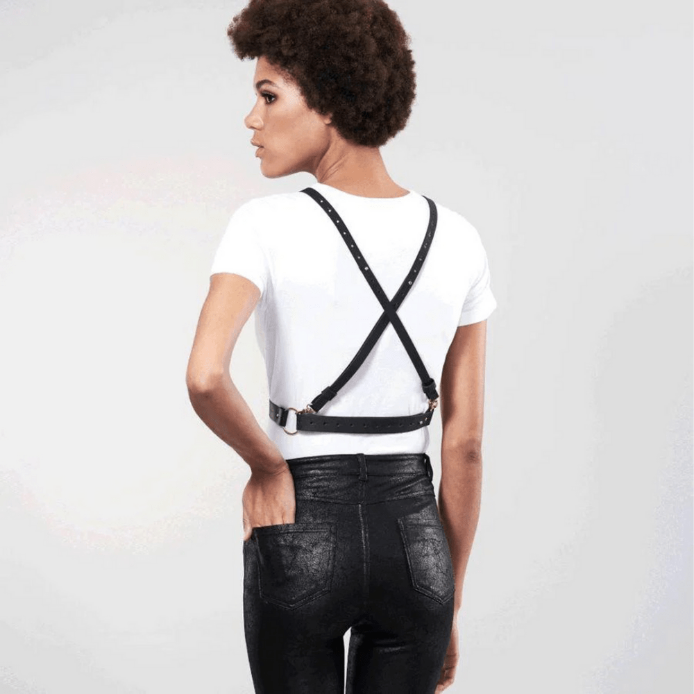 Zijaanzicht van model met zwart vegan leren cross cleavage harnas van Bijoux Indiscrets voor elegante bodystyling