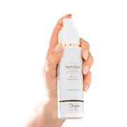 Hand met Orgie Sensfeel fles – haar- en lichaamsemulsie met feromonen 100 ml