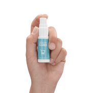 Hand die de Pharmquests Grocery Cleaner 15 ml vasthoudt, kleine desinfectiespray die gericht reinigen