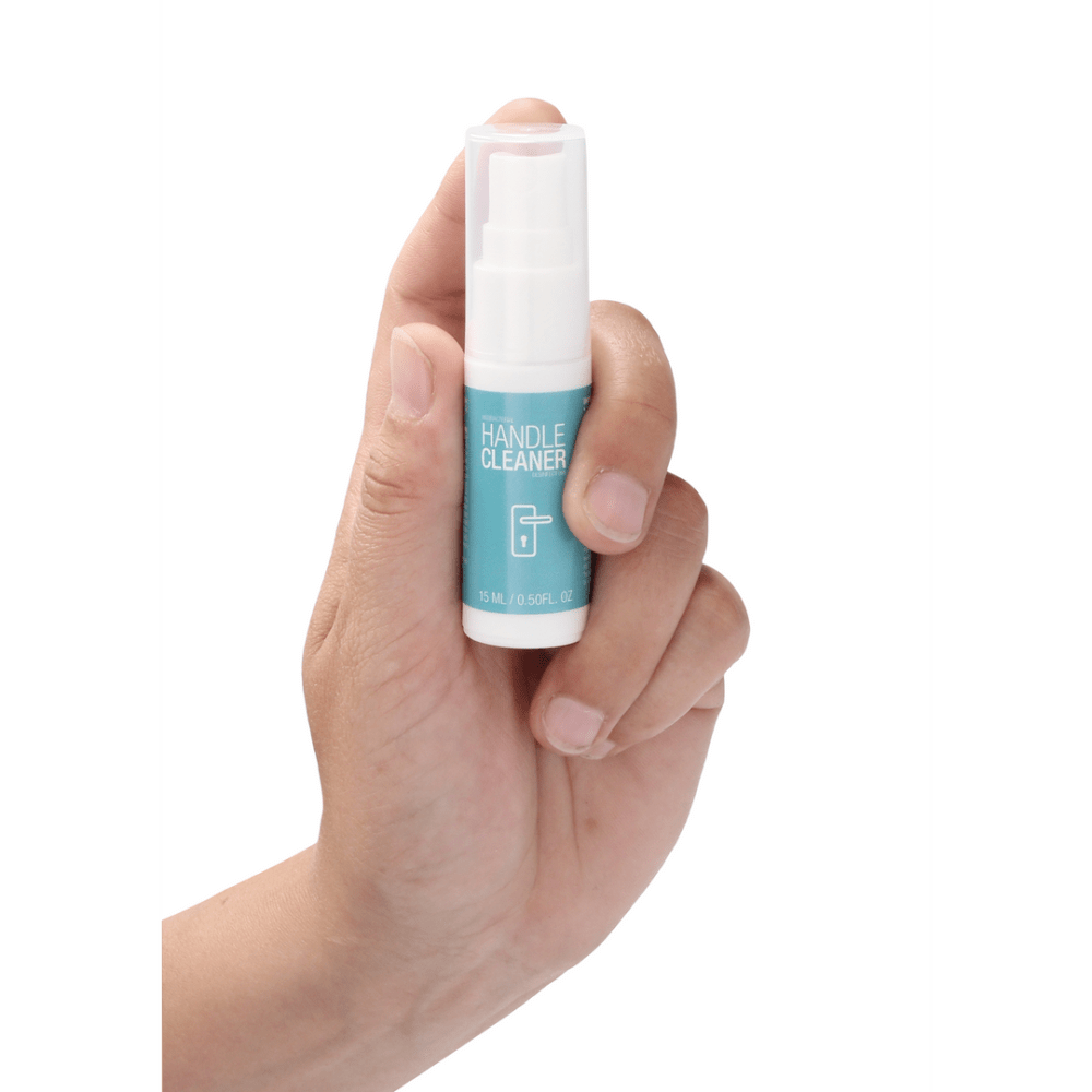 Hand die de Pharmquests Handle Cleaner 15 ml vasthoudt, compacte desinfectiespray voor snelle en gerichte reiniging