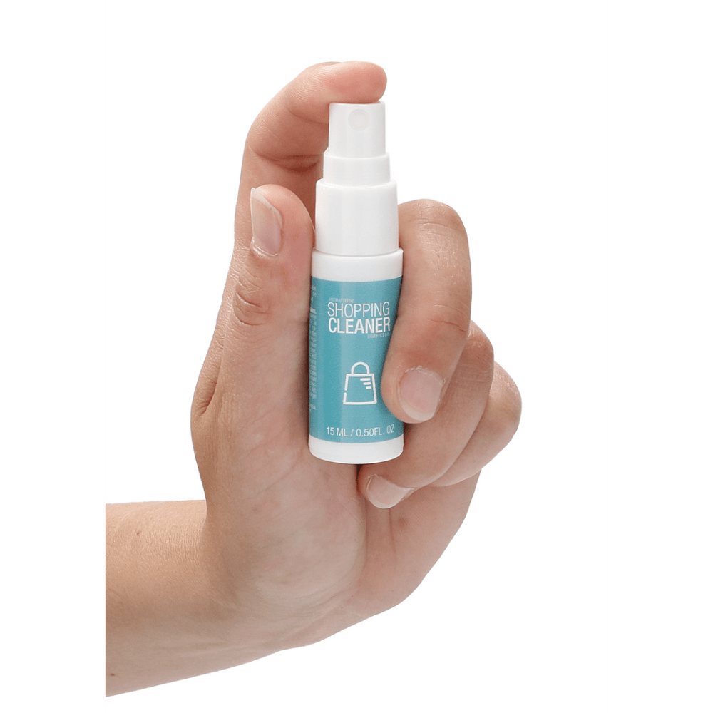 Hand die de Pharmquests Antibacterial Shop Cleaner 15 ml vasthoudt, toont compacte spray voor snelle en gerichte reiniging