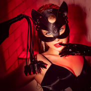 Close-up van Mapalé oogmasker op model, gedragen met zwarte lingerie en warme rode belichting