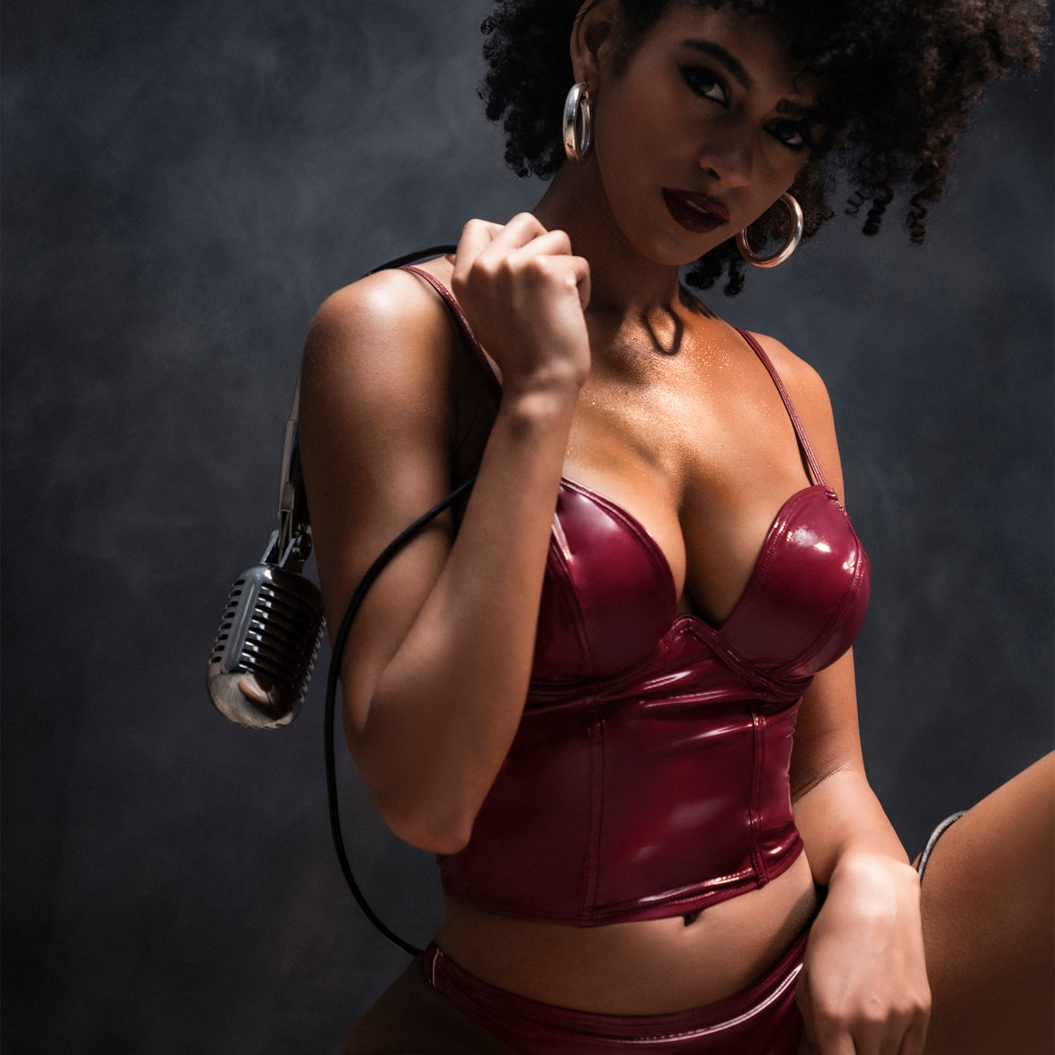 Mapalé bustier set wetlook wijnrood maat L, studioportret met microfoon over schouder, glossy lingerie set