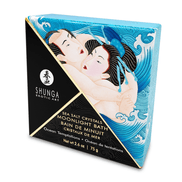 Schuin geplaatste verpakking Shunga Mini Ocean Breeze badzout 75 gr met blauwe kristallen ernaast