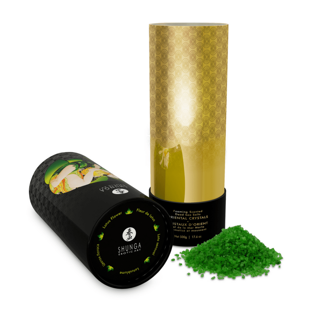 Shunga Lotus badzout 500 gr, liggende pot met gouden dop en groene kristallen ernaast in een minimalistische studiosetting