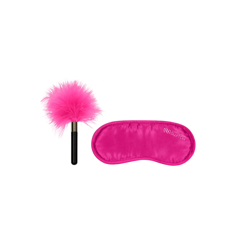 Roze veren kietelaar met zwart handvat naast roze satijnen blinddoek met Switch logo.