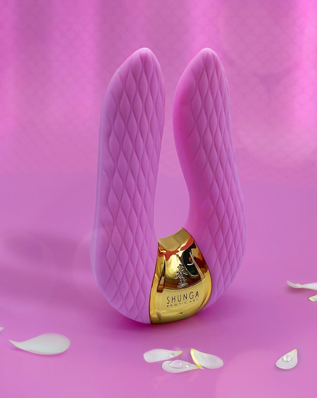 een roze Shunga Aiko vibrator met witte blaadjes en een roze achtergrond