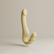 Odes Within strapless strap-on vibrator in beige, zwevend gefotografeerd met gebogen vorm en zachte afwerking