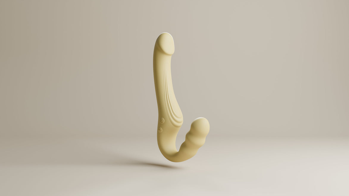 Odes Within strapless strap-on vibrator in beige, zwevend gefotografeerd met gebogen vorm en zachte afwerking