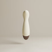 Beige mini wand vibrator frontaal gefotografeerd, met slanke body, ronde kop, powerknop en bruine basis