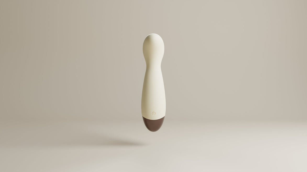 Beige mini wand vibrator frontaal gefotografeerd, met slanke body, ronde kop, powerknop en bruine basis