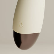 Detail van Odes Ease Mini Wand Vibrator met beige body, subtiele powerknop en glanzende bruine onderzijde
