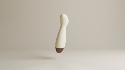 Odes Ease Mini Wand Vibrator in beige, schuin zwevend met afgeronde kop, powerknop en bruine onderzijde