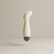 Beige Odes Ease mini wand vibrator in glad zijaanzicht, met gebogen kop en donkere afgeronde basis