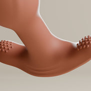 Terracotta roterende buttplug met geribbelde zijvlakken op de brede basis, close-up van de onderzijde