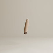 Odes Intima Mini Bullet Vibrator in schuin zijaanzicht, met gladde beige body en donker afgerond voetje