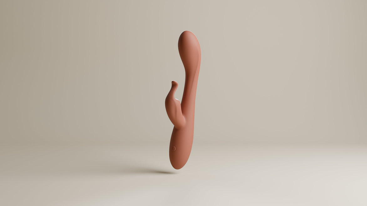 Odes Lustra Tarzan vibrator in terracotta, staand in studio met gebogen vorm en kleine stimulator