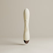 Witte Tarzan vibrator frontaal gefotografeerd, met slanke body, afgeronde top en subtiel knopdetail onderaan