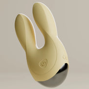 Beige Odes Sense wand vibrator liggend op licht oppervlak met warme zonval en zachte schaduw