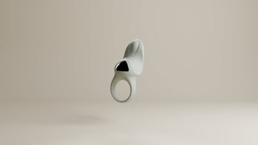 Odes Surrender vibrerende cockring in lichtgrijs, frontaal zwevend met open ring en zwarte accentplaat