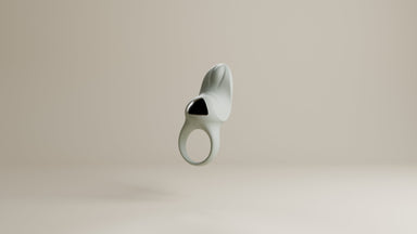 Odes Surrender vibrerende cockring in lichtgrijs, frontaal zwevend met open ring en zwarte accentplaat