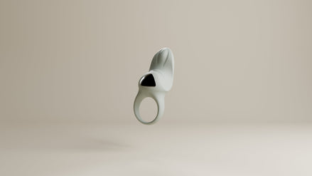 Odes Surrender vibrerende cockring in lichtgrijs, frontaal zwevend met open ring en zwarte accentplaat