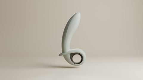 Odes Swell grijze anale vibrator met gebogen vorm, brede basis en ronde ring op beige studioachtergrond