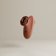 Odes The Touch clitorisvibrator in terracotta, zwevend in driekwartaanzicht met roosvormige kop en laadpunten