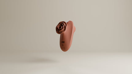 Odes The Touch clitorisvibrator in terracotta, zwevend in driekwartaanzicht met roosvormige kop en laadpunten