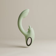 Saliegroene Odes Unite rabbit vibrator met gebogen schacht en ringvormig handvat op beige achtergrond