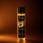 Alt-tekst
Orgie Sexy Therapy Amor massageolie in een transparante fles met goudkleurige olie, zwart etiket met gouden maskerillustratie en zwarte dop, warm uitgelicht tegen een koperbruine achtergrond