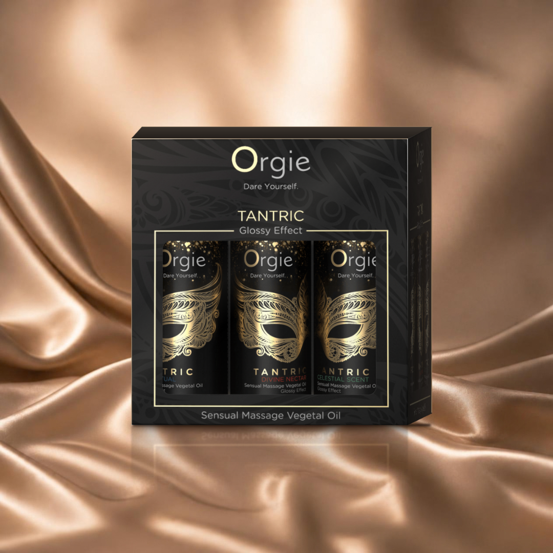 Orgie Tantric Glossy Effect mini massageolie set met drie flesjes in zwart-gouden doos op champagnekleurig satijn