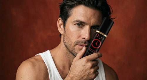 Mannelijk model met Orgie Time Lag 2 spray tegen warme rode achtergrond, luxe sfeerbeeld voor heren