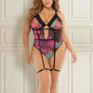 Vrouw met rondingen in een transparante body met roze, paarse en turquoise bloemenprint, open decolleté en jarretelbandjes