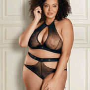 Plus size model in een elegante zwarte kanten lingerieset voor een klassieke crèmekleurige muur met vakwerk