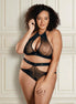 Plus size model in een elegante zwarte kanten lingerieset voor een klassieke crèmekleurige muur met vakwerk