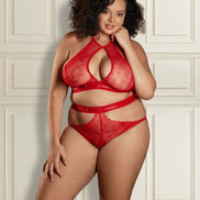Vrouw met krullend haar in een rode kanten lingerieset: halter-bh met druppelvormige opening, taillebandje en slip