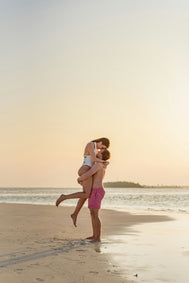 Koppel omhelst elkaar op het strand bij zonsondergang, warm sfeerbeeld voor verbinding en Touch-Me nieuwsbrief