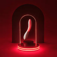 Witte MONA Spectra op rood verlicht podium onder een lichtboog